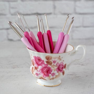 pink crochet hooks in teacup