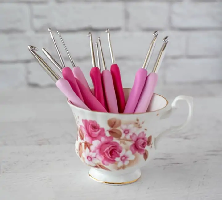 pink crochet hooks in teacup