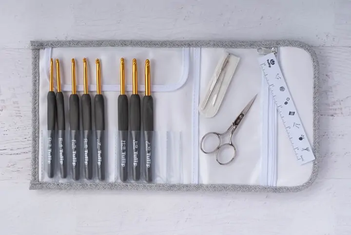 gray crochet hooks in case with scissors, needles and ruler