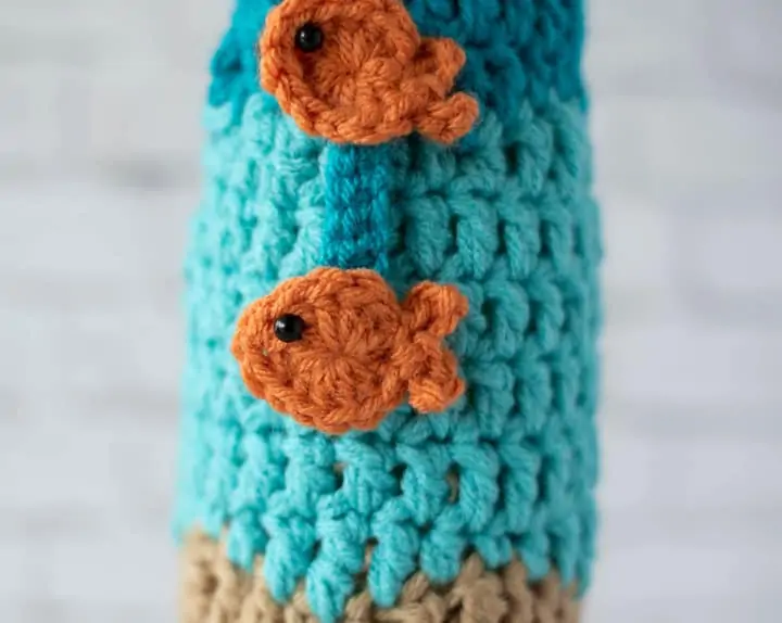 close up of orange fish on blue wine cozy