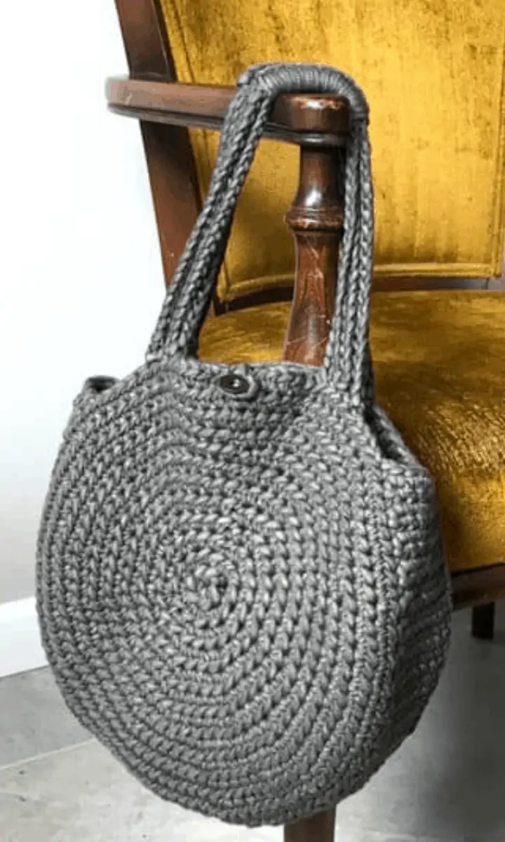 crochet circle-shaped bag hanging on a chair