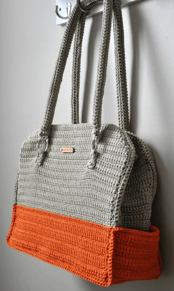 grey and orange crochet bag hanging up