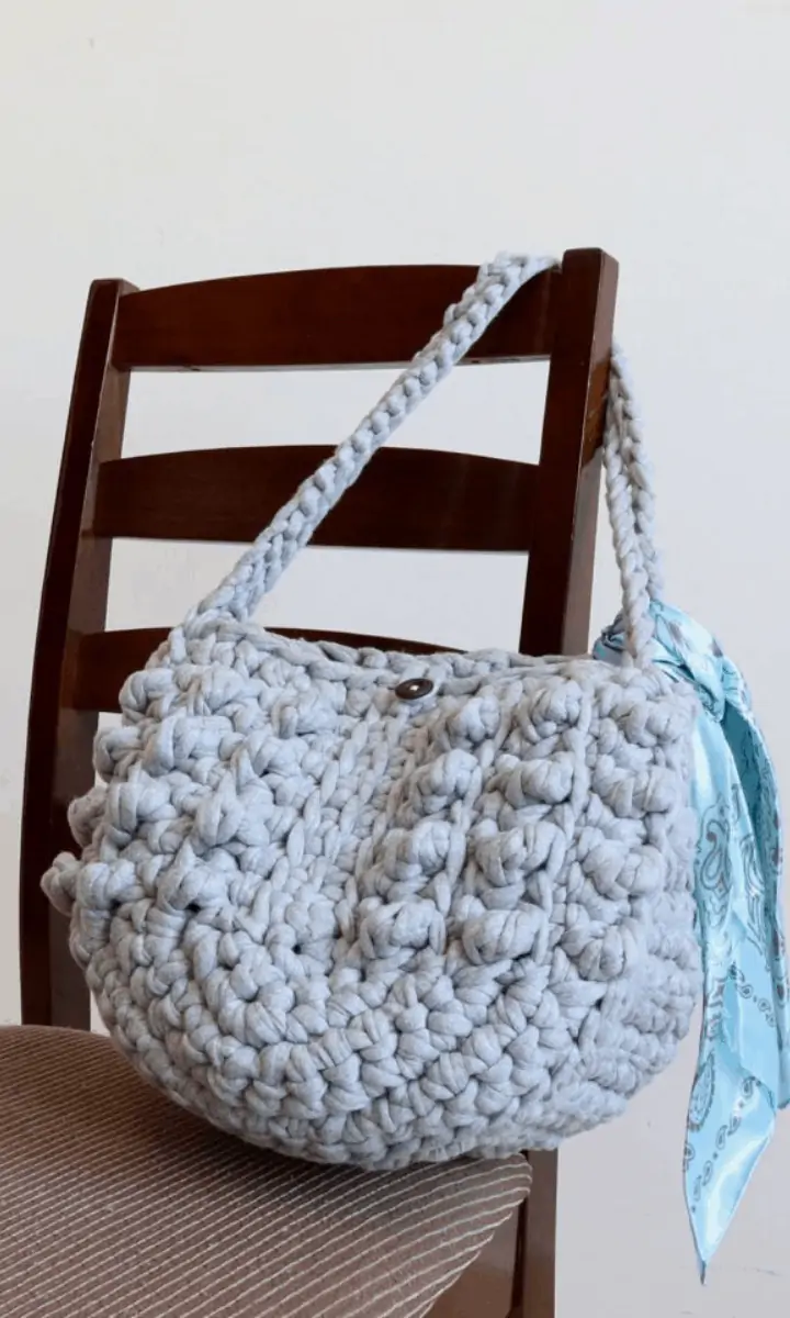 grey crochet bag hanging on a chair