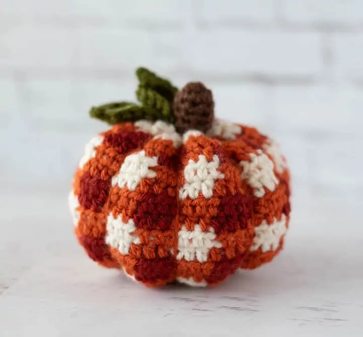 crochet orange plaid pumpkin with brown steam and green leaves