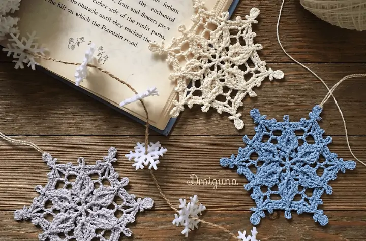 three crochet snowflakes in various colors