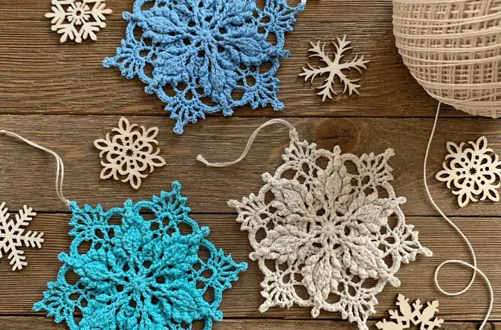 three crochet snowflakes in various colors