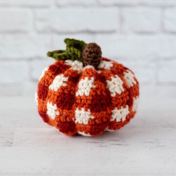 crochet orange plaid pumpkin with brown steam and green leaves