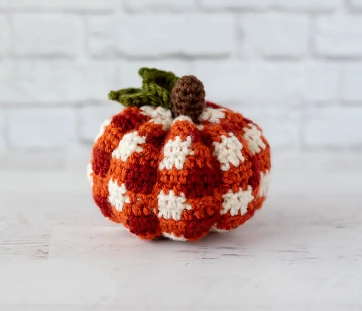 crochet orange plaid pumpkin with brown steam and green leaves