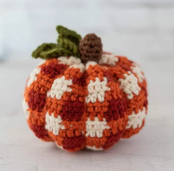 crochet orange plaid pumpkin with brown steam and green leaves