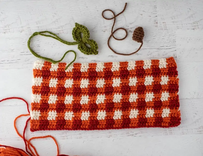 crochet orange plaid rectangle, green leaves and brown stem