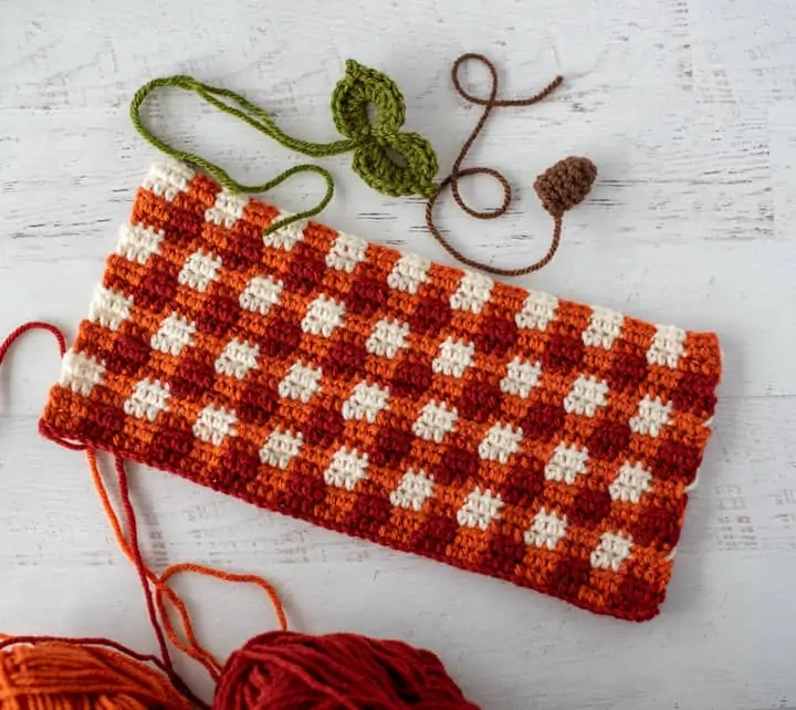crochet orange plaid rectangle, green leaves and brown steam