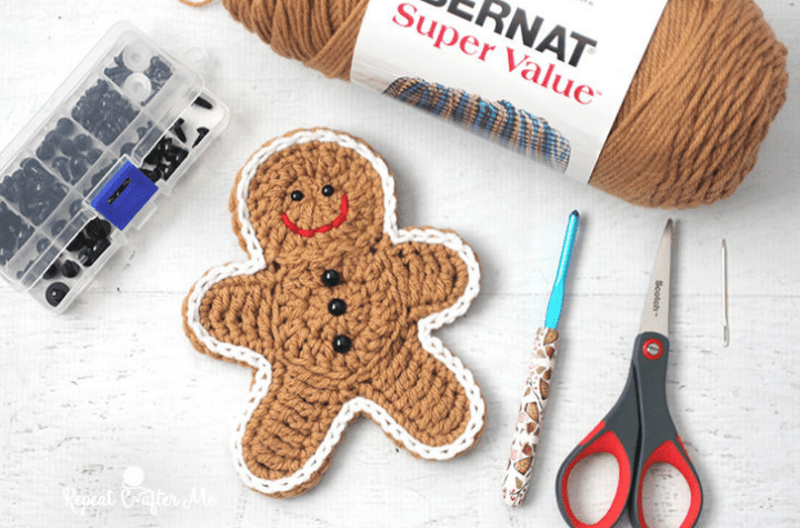 crochet gingerbread with hook, yarn, scissors, and buttons