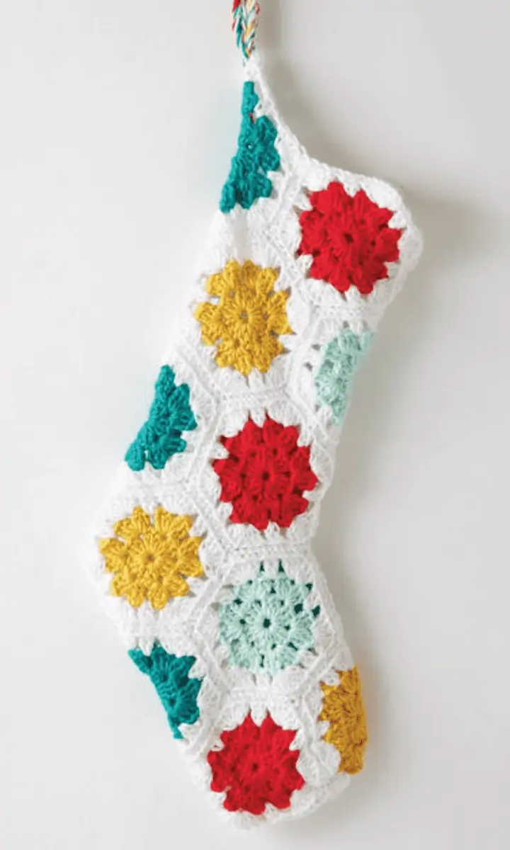 white crochet granny stocking with blue, red, and yellow circles