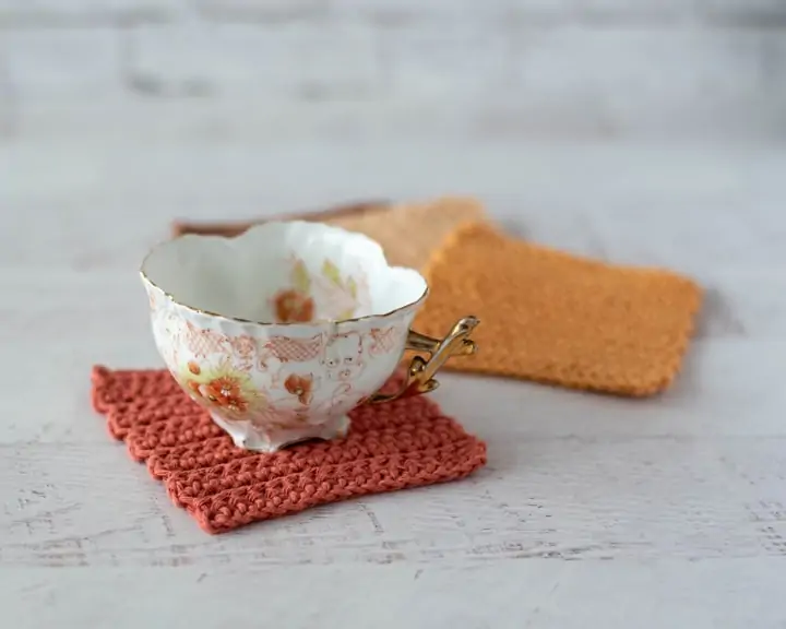 Coffee cup on rust color crochet coaster