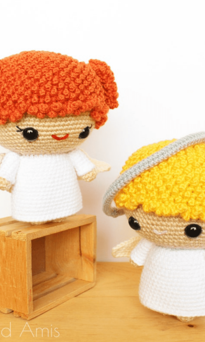 two white crochet angels: one redhead girl and one blonde boy