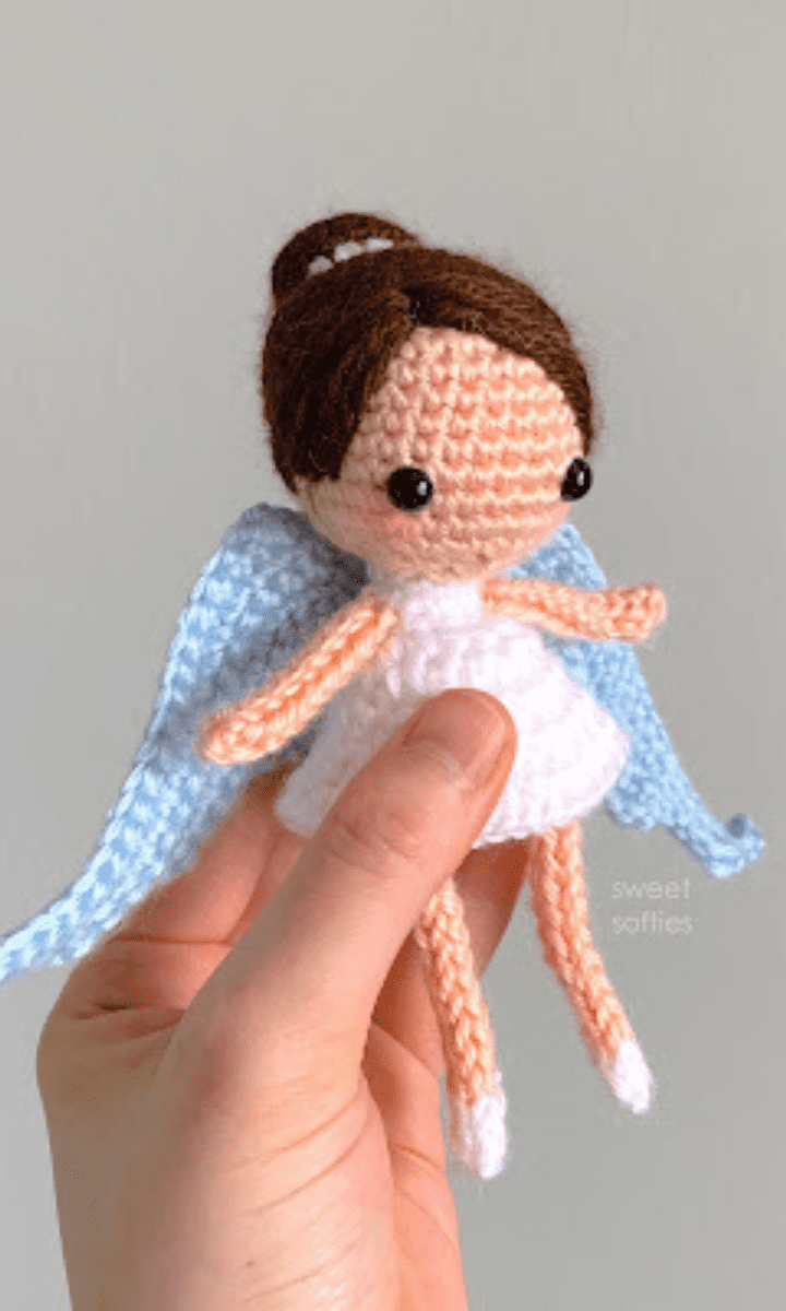 white crochet angel amigurumi with brown hair and blue wings