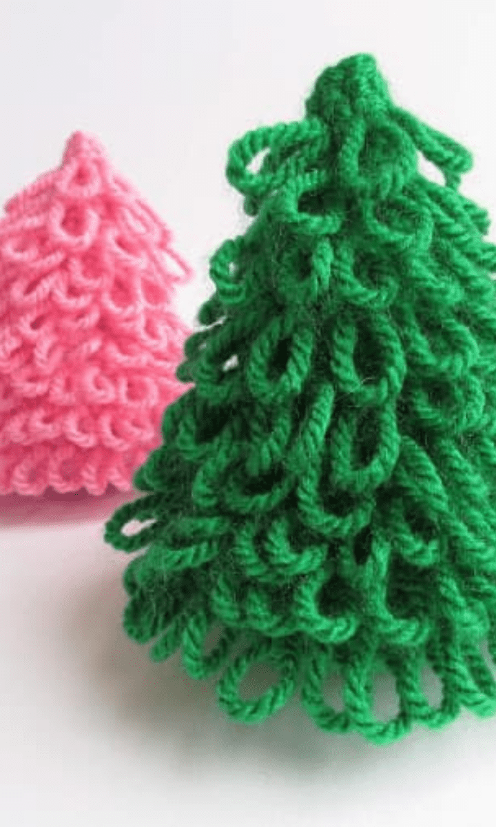 two crochet loopy christmas trees, one green and one pink