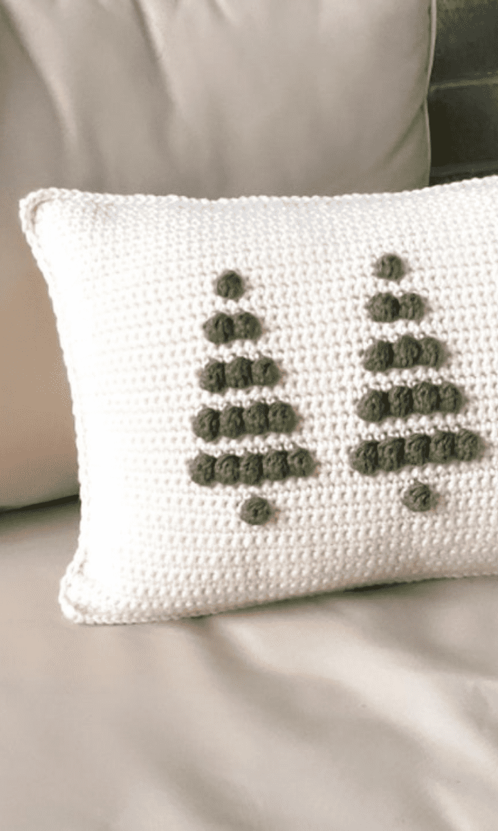 white crochet pillow with christmas tree bobbles