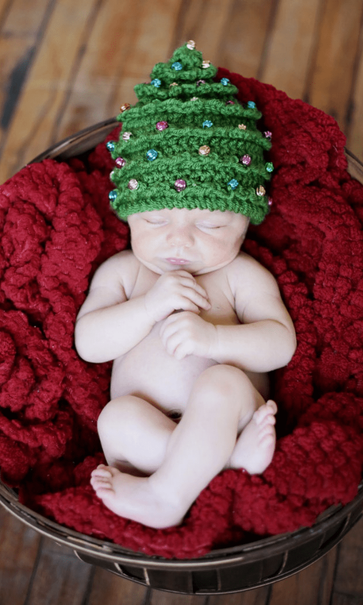 baby in basket with christmas tree hat