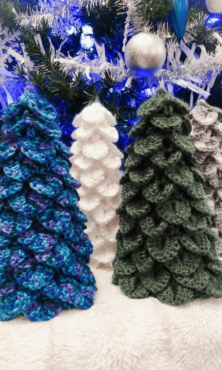crochet christmas trees of various colors and sizes