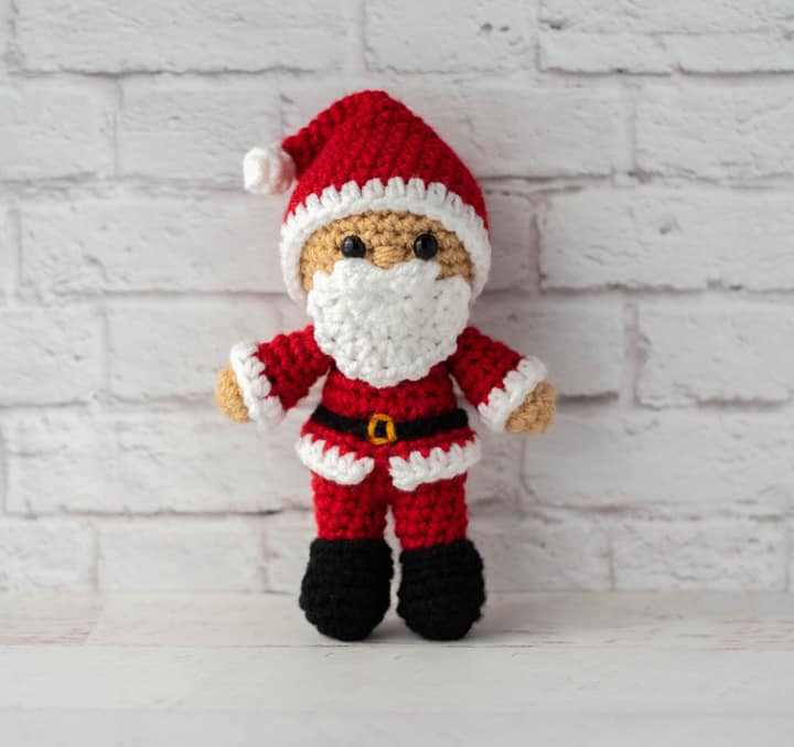 Crochet Santa in red suit, black boots and red and white hat.