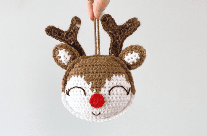 fingers holding crochet reindeer head ornament