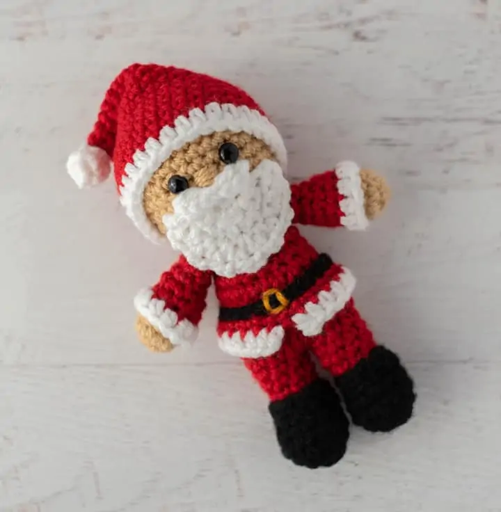 Crochet Santa in red suit, black boots and red and white hat.