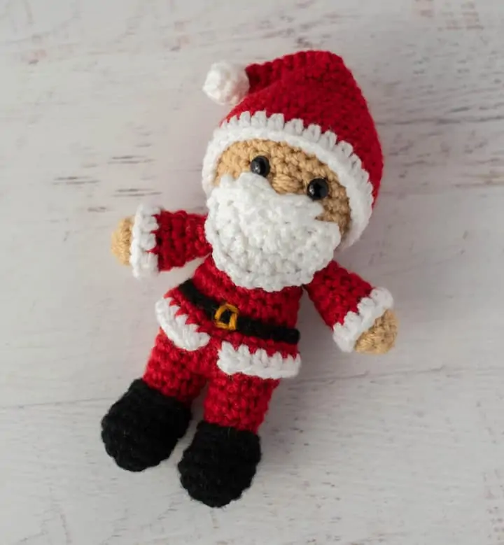 Crochet Santa in red suit, black boots and red and white hat.