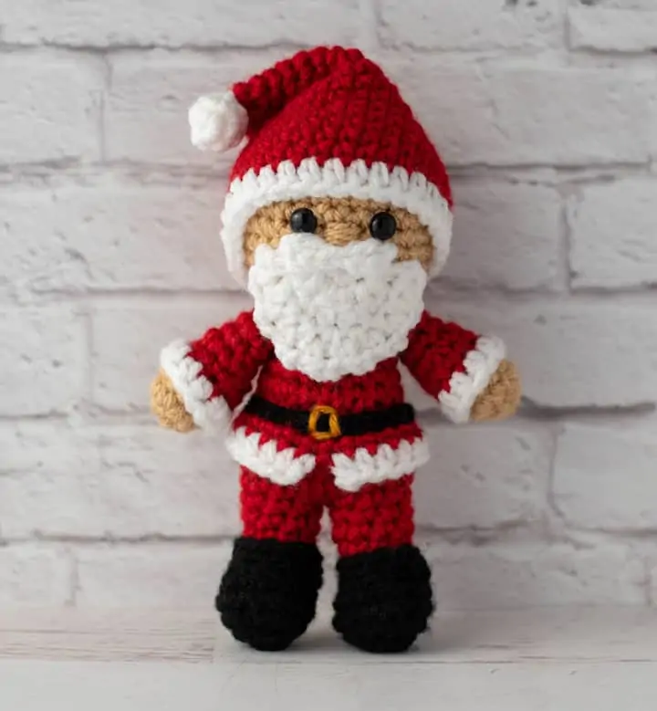 Crochet Santa in red suit, black boots and red and white hat.