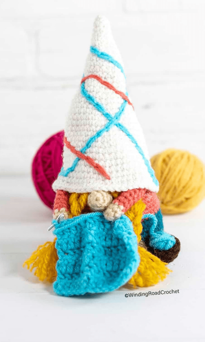 crochet gnome crocheting with yarn in the background