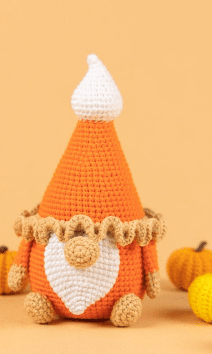 crochet pumpkin pie gnome with little pumpkins in the background