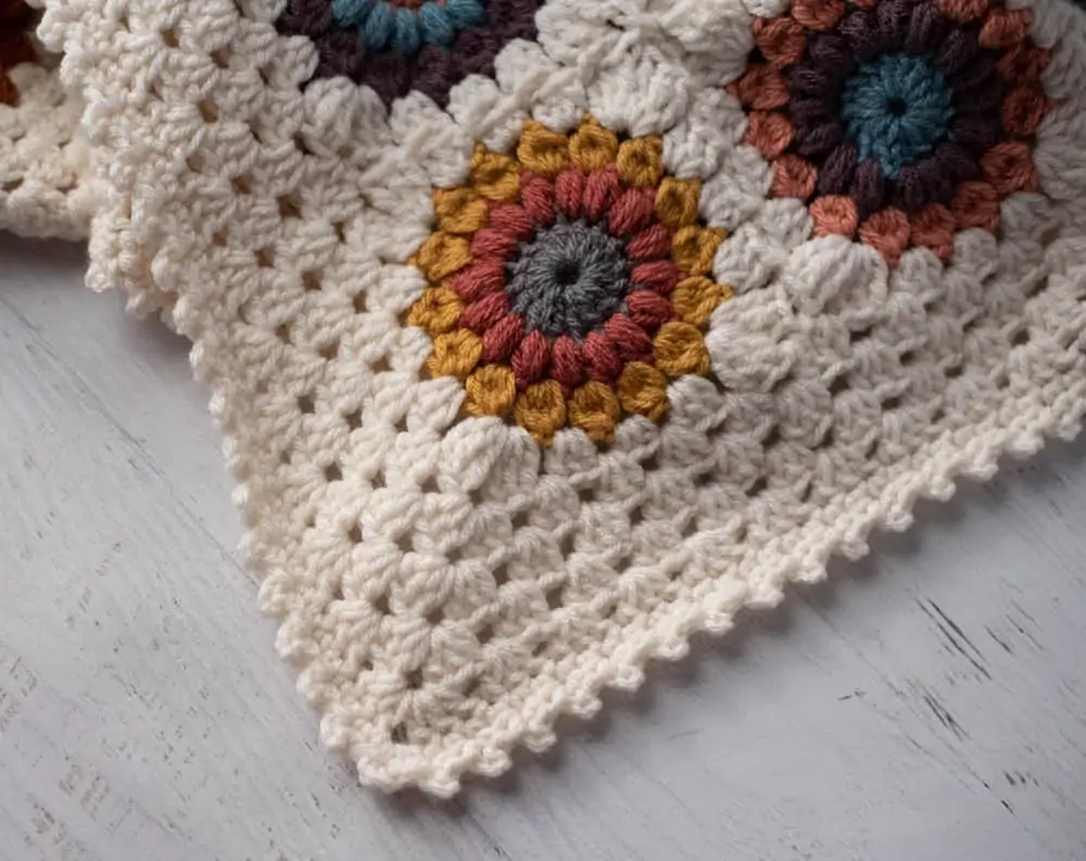 Corner of Crochet multi color afghan with ivory border