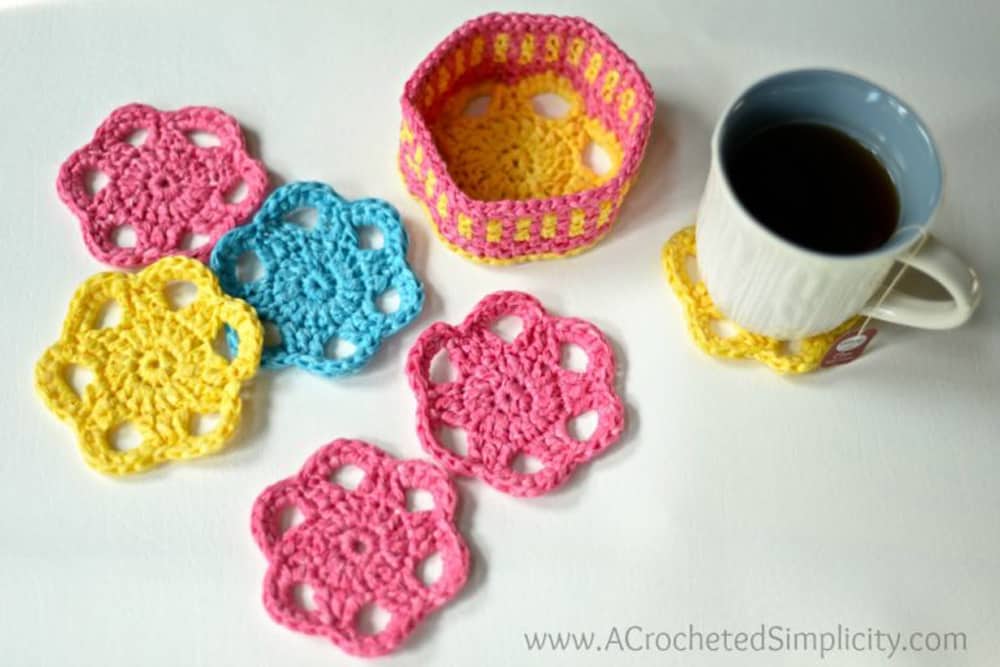 pink, yellow and blue coasters with holder and coffee mug