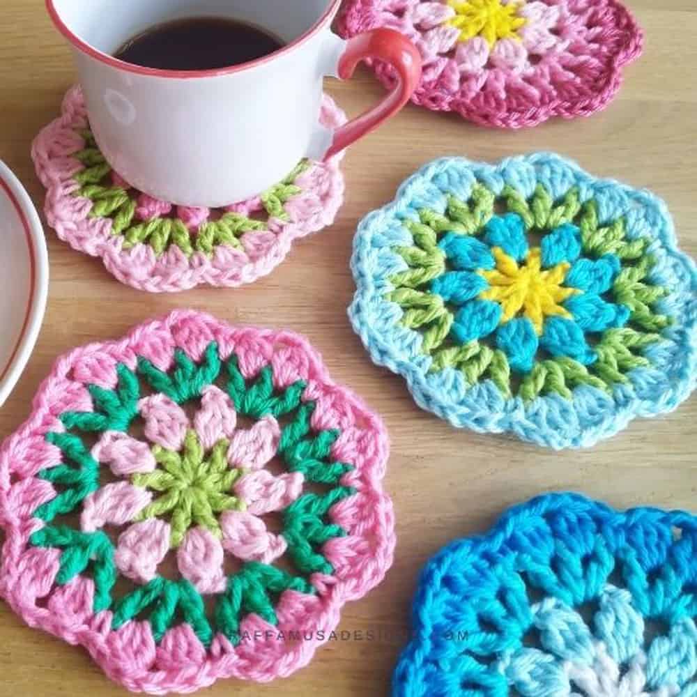 pink, green and blue crochet flower coasters with coffee cup