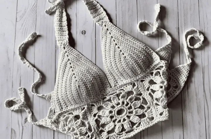 White bralette with flower designs along the bottom and ties in the back