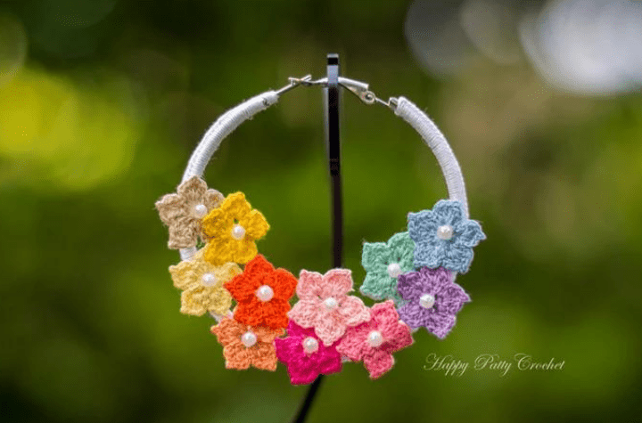 Boucle d'oreille créole au crochet qui affiche principalement des fleurs multicolores.