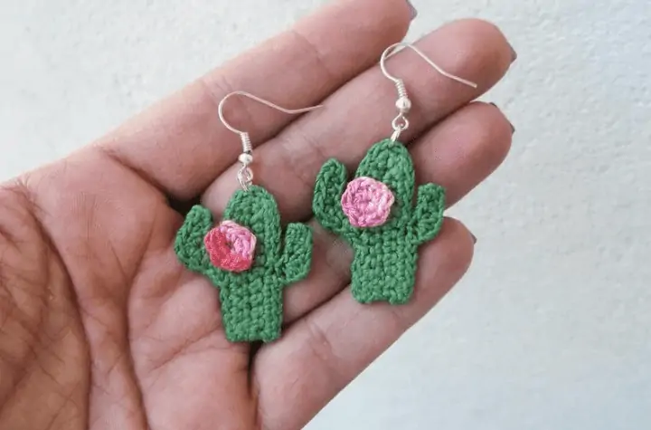 Cactus crochet earrings with a pink flower.