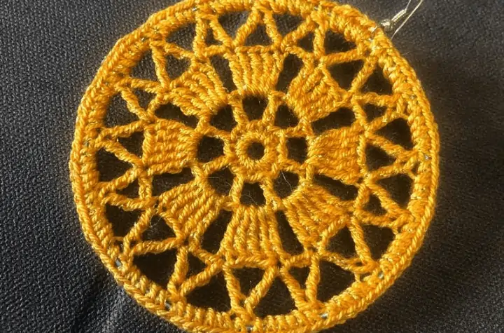 Crochet hoop earring with a design that features a lot of gaps in the yarn