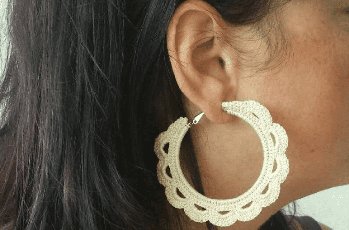 Crochet hoop earrings that look like a white sun.