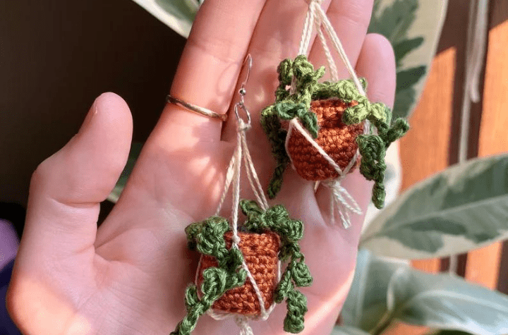 A pair of crochet earrings that look like little hanging planters.