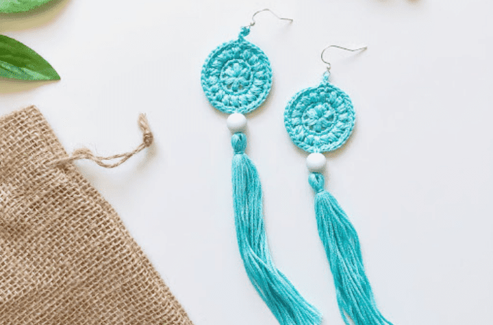 Boucles d'oreilles au crochet bleu qui ont un cercle en haut avec un long pompon en bas.