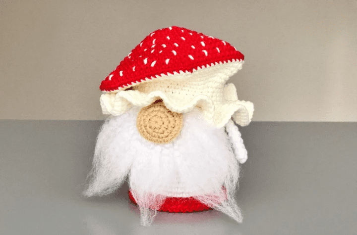 Small crochet mushroom gnome featuring a white beard