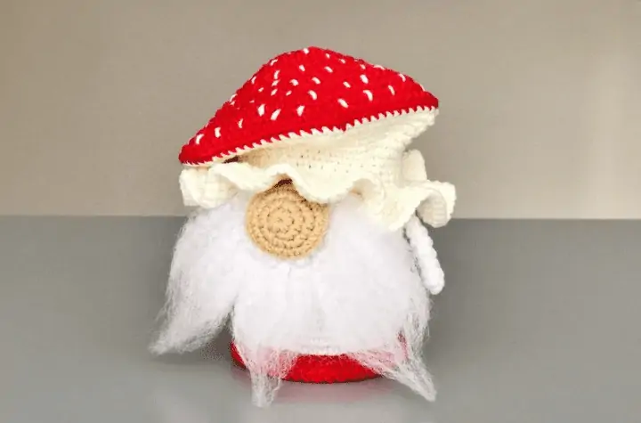 Small crochet mushroom gnome featuring a white beard