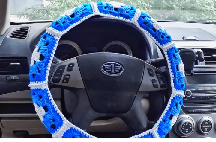 Granny square style crochet steering wheel cover with floral patterns.