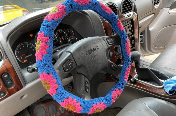 Floral Steering Wheel Cover using pink, blue, and yelow yarn