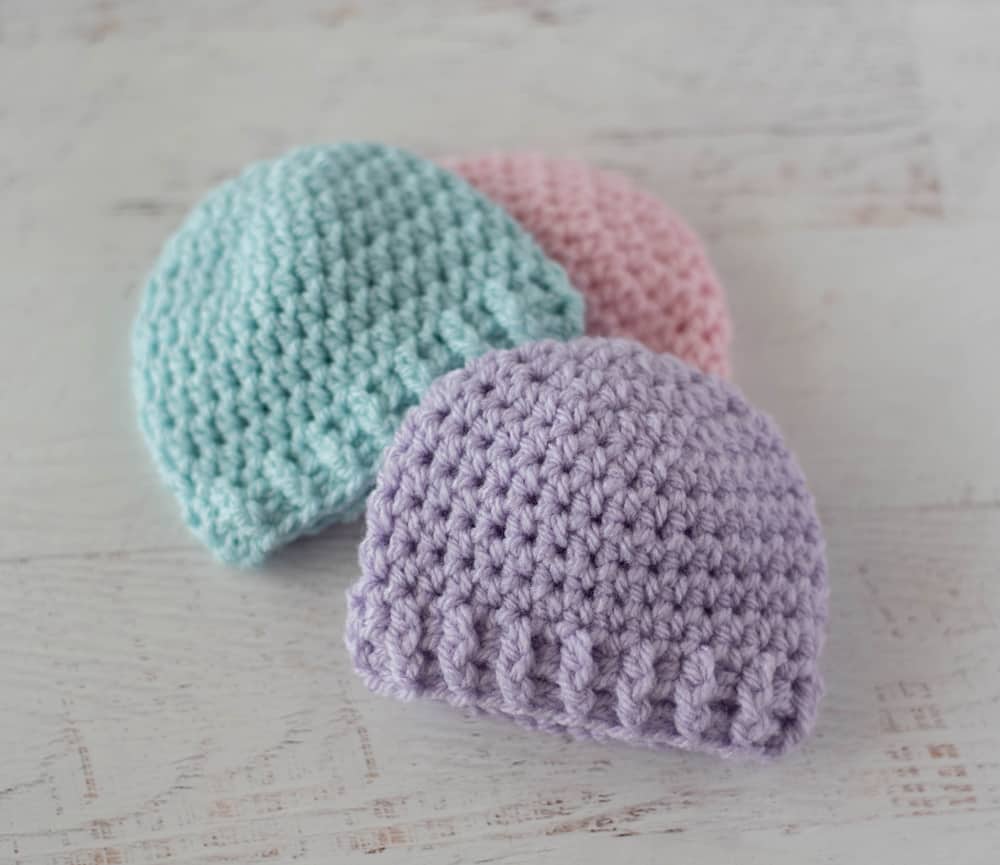 3 crochet preemie hats in purple, blue and pink