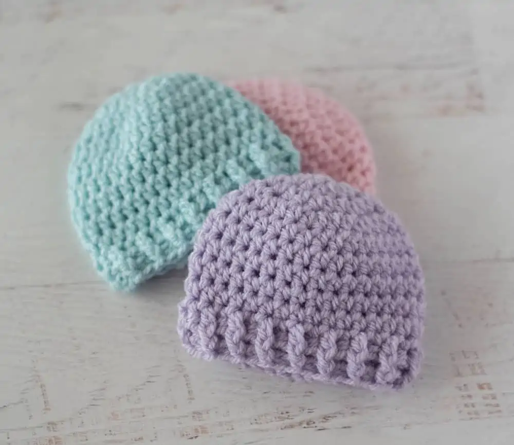 3 crochet preemie hats in purple, blue and pink