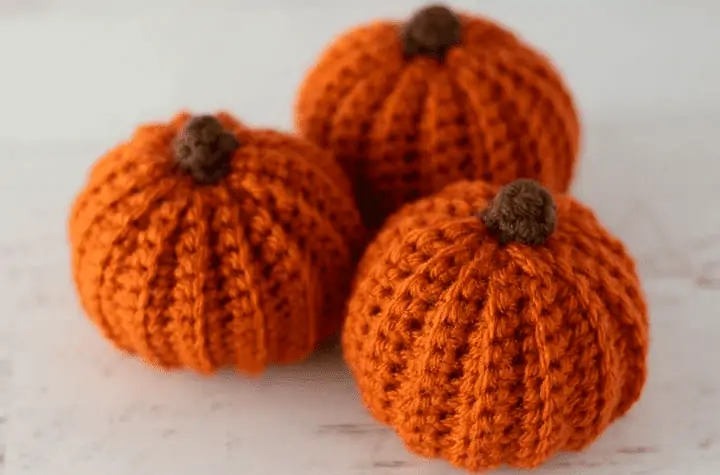 Three small crochet pumpkins.
