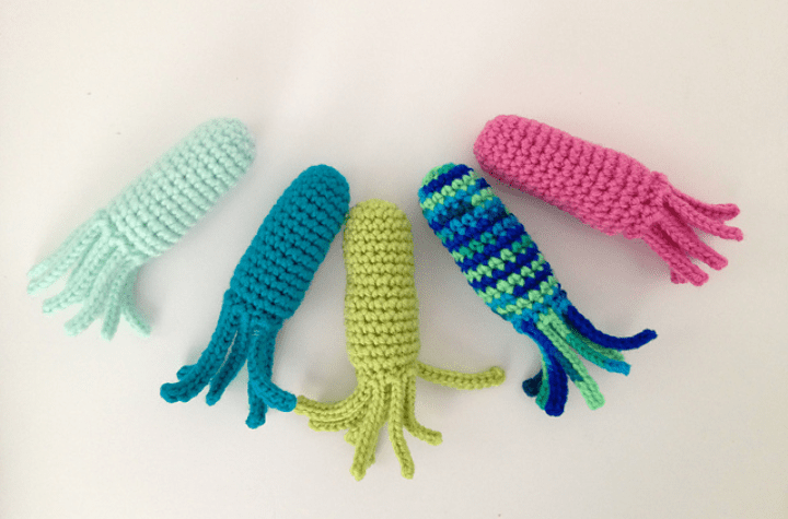 Cinq jouets de calmar au crochet.
