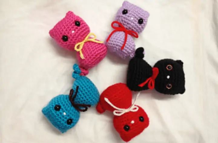 Five small cat-shaped cat toys in multiple colors.